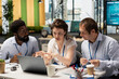 © DC Studio - African American and Caucasian colleagues sitting together in modern office, reviewing financial charts on laptop. Male and female employees showcasing teamwork, productivity and corporate strategy.