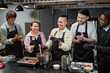 © TrueFrame Collective - Group of young adult multiethnic men and women standing in kitchen preparing dessert together, smiling and laughing