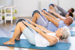 © JackF - People of different ages doing pilates exercises with fitness ball during group training at gym