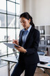 © David - Asian woman in business holding digital computer, looking at camera. Portrait of middle eastern Israel businesswoman using tablet pc online app for work isolated on white background.