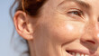 © Marut - Close up of cheek ear and eye area with radiant skin soft light clear complexion visible freckles and natural smile lines expressing happiness and healthy appearance