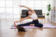 © David - Female asian Yoga instructor conducting an online class with laptop