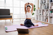 © David - Female asian Yoga instructor conducting an online class with laptop
