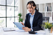 © David - Business asian woman working at office with tablet and document, doing planning analyzing the financial report Tax Advisory Firm.