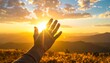 © Randu - Human hand reaching for golden sun rays at vibrant sunset over a majestic mountain landscape.