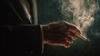 © florynstudio3 - Close-up of a person's hand holding a lit cigarette, with smoke billowing upwards against a dark background, in a dim environment