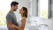 © Julia - Happy young couple smiling tenderly and looking at each other while standing in bright modern bathroom, concept of love, life together and comfort.