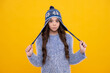 © Olena - School girl in winter clothes and warm hat. Winter holiday vacation. Child fashion model. Surprised teenager girl.