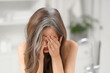 © Pixel-Shot - Upset young woman with graying hair in bathroom, closeup