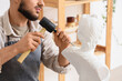 © Pixel-Shot - Male sculptor carving bust in workshop, closeup