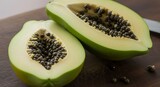Fresh Green Papaya Halved on Wooden Board with Seeds Visible.