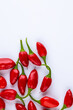 © mitsyko1971 - Vibrant red jalapeno pepper on a white background with space for text, ideal for food and culinary concepts.Group of ripe red jalapeno peppers .