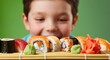 © Alexandr - Boy leaning over sushi rolls on bamboo mat with eager expression and excited smile