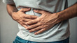 © mh - Man holding stomach area in apparent physical discomfort