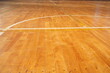 © Masakazu Tokashiki - A basketball court with a white line in the middle. The court is empty and the floor is made of wood