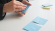 © kinomaster - Organizing Notes with Blue Sticky Papers on Desk