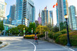 © unai - Student cycling in downtown vancouver with canadian flags waving