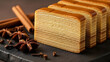 © yustian dmyth - Close up of layered cake with spices on dark surface