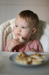 © splitov27 - Little baby eats cheesecakes at the feeding table