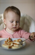 © splitov27 - Little baby eats cheesecakes at the feeding table