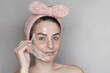 © Katyart - Caucasian woman makes a cosmetic Peel Off Mask. She removes the film mask with her hand copy space photo