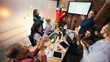 © master1305 - Team collaboration around table in modern coworking office. Concept of shared work process, cross functional teamwork, collaborative office culture.