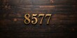 © MetaPixel - Wooden numerals 8577 painted in gold on a dark brown and white patterned plank background, serving as a vintage home concept with textured design elements