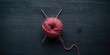 © ArtificialHorizons - Knitting tools and wool ball arranged on a dark gray wooden table, ideal for textile layout backgrounds
