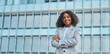 © insta_photos - Happy confident young African American business woman standing on street. Smiling pretty professional businesswoman model with curly hair wearing suit looking at camera in big city, portrait. Banner