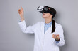 © New Africa - Modern technology. Doctor using virtual reality headset on grey background