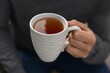© New Africa - Man with cup of hot tea indoors, closeup