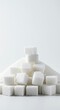 © retirementfun - A large mound of clean, crisp white granulated sugar cubes stacked and scattered across a bright white background, symbolizing sweetness and energy, texture, delicious, cooking