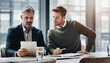 © Rifqi - Two male corporate executives, a CEO and a manager, reviewing a tablet and documents during an intense meeting, concept for business strategy, corporate finance and technology consultation