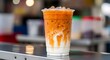 © BackgroundStudio - Refreshing Iced Thai Milk Tea (Cha Yen) with creamy condensed milk and ice.