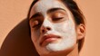 © irawan - Woman with facial mask enjoying skincare routine in sunlight.