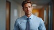 © KP - An attractive man in a blue shirt and tie walking in corridor