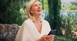 © EineroLens/peopleimages.com - Funny, smartphone and woman with internet, outdoor and laughing with social media. Mature person, happiness and cellphone with communication, humor or message to contact, online comedy or digital app