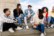 © Xavier Lorenzo - Multiracial group of young teenage student friends laughing together sitting outdoor. Youth community concept