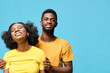 © SHOTPRIME STUDIO - Happy young couple in matching yellow outfits smiling against a blue background, showcasing friendship and affection in a joyful moment