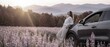 © Michael - Woman enjoys sunset view beside car in a flower field