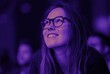 © Vishwesh - woman thinking dreaming happy while smiling under purple neon light in audience – stock photo