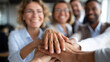 © Nataliya - Leadership faceless team stacking hands and smiling at each other at corporate office, defocused unity gesture, collaborative bonding, team solidarity moment, collective commitment