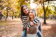 © Jelena - Joyful girls enjoying autumn together in a colorful park setting