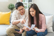 © KMPZZZ - Stressed financial owe asian young couple love sitting suffer, stressed and confused by calculate expense from credit card bill, no money to pay, mortgage or loan. Debt, bankrupt or bankruptcy people.