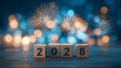 © Patryk Wolanowski - Nowy Rok 2028 z drewnianymi klockami i fajerwerkami na niebieskim tle