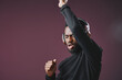 © SHOTPRIME STUDIO - A joyful African man in headphones dancing energetically against a deep purple background, showcasing emotions of happiness and enthusiasm through music