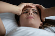 © fizkes - Overthinking insomnia. Close up shot nervous distressed young woman lying on pillow without sleep hug head think about problems make difficult decision feel concern depression pressure of hard choice
