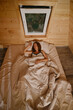 © boomeart - Woman sleeping in a wooden room