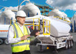 © Grispb - Chemical plant, industrial inspection. Safety engineer checks process data on a tablet near storage tanks and tanker trailer, overseeing operations, logistics, and compliance.