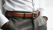 © PACHARA - A man wearing a brown belt and gray pants